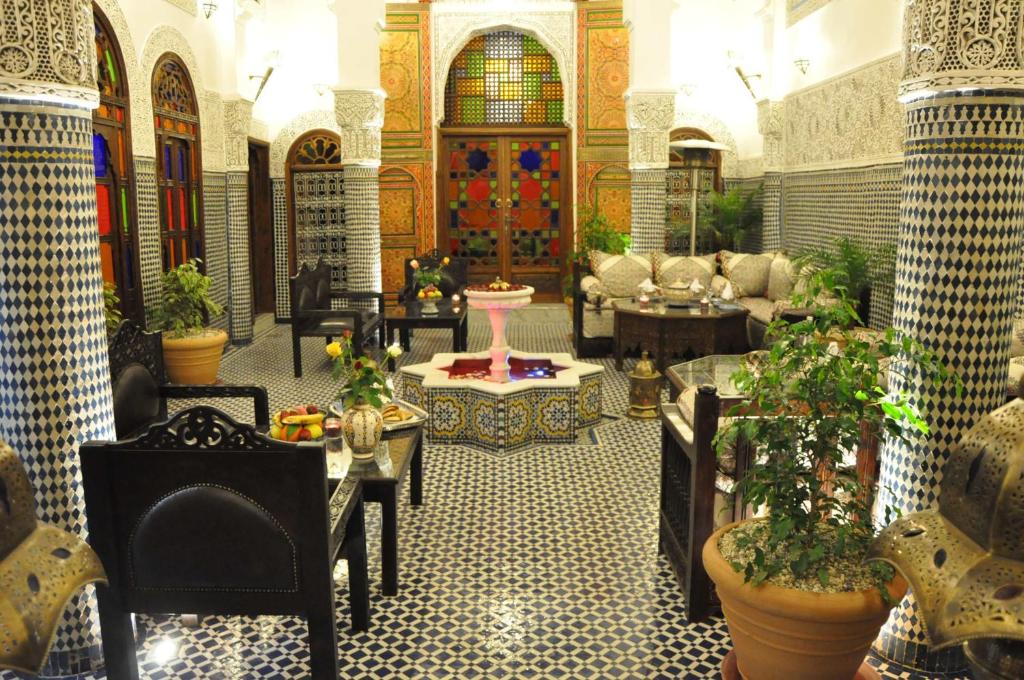 a lobby with tables and chairs in a building at Riad Ghita Palace in Fès