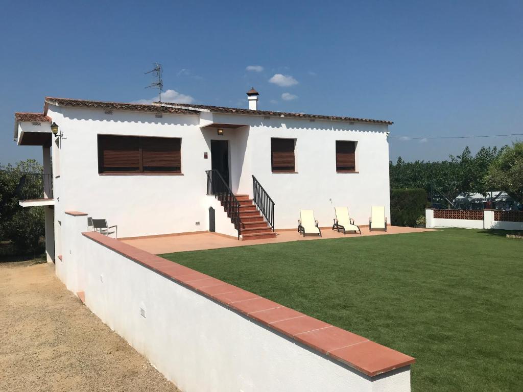 una casa blanca con césped delante en Mas Tauler, en Sant Antoni de Calonge