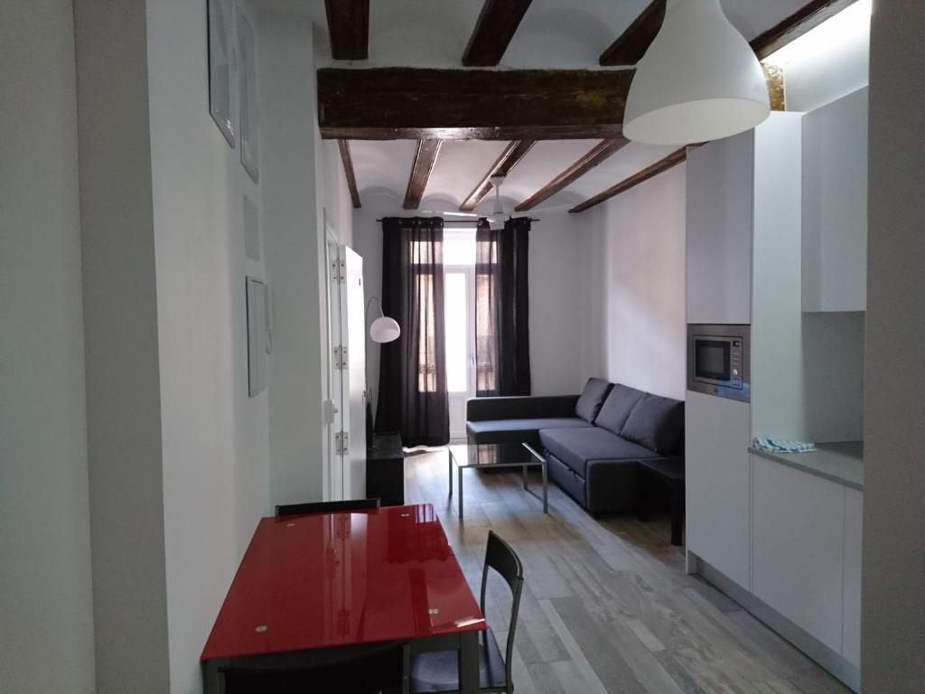 a living room with a red table and a couch at NWT Central Station Apartments in Valencia