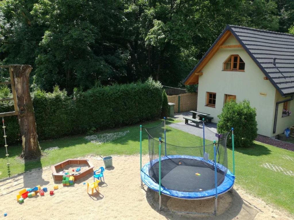 einen Spielplatz mit Trampolin im Hof in der Unterkunft Domki Na Źródlanej in Mienzebrosche
