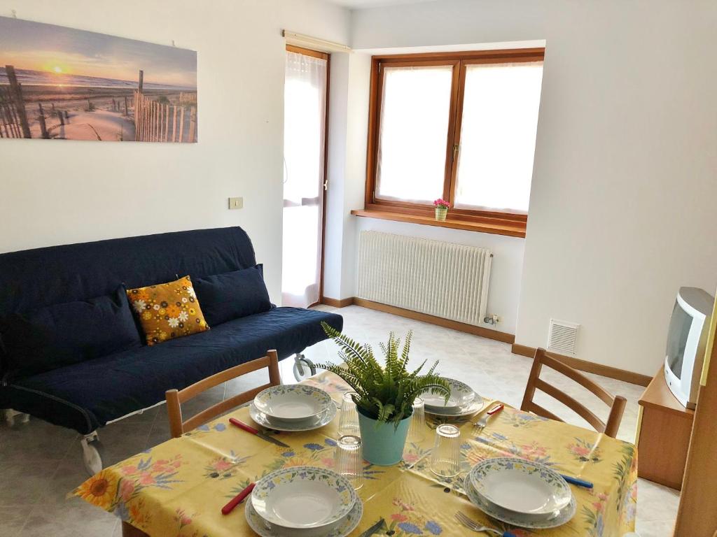 a living room with a table and a couch at Residence Viale del Sole in Grado