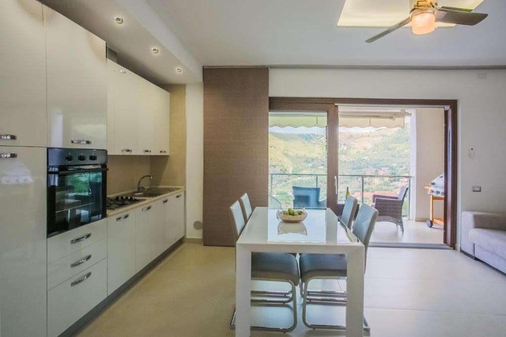 uma cozinha e sala de jantar com uma mesa branca e cadeiras em Arca Superior em Cefalù