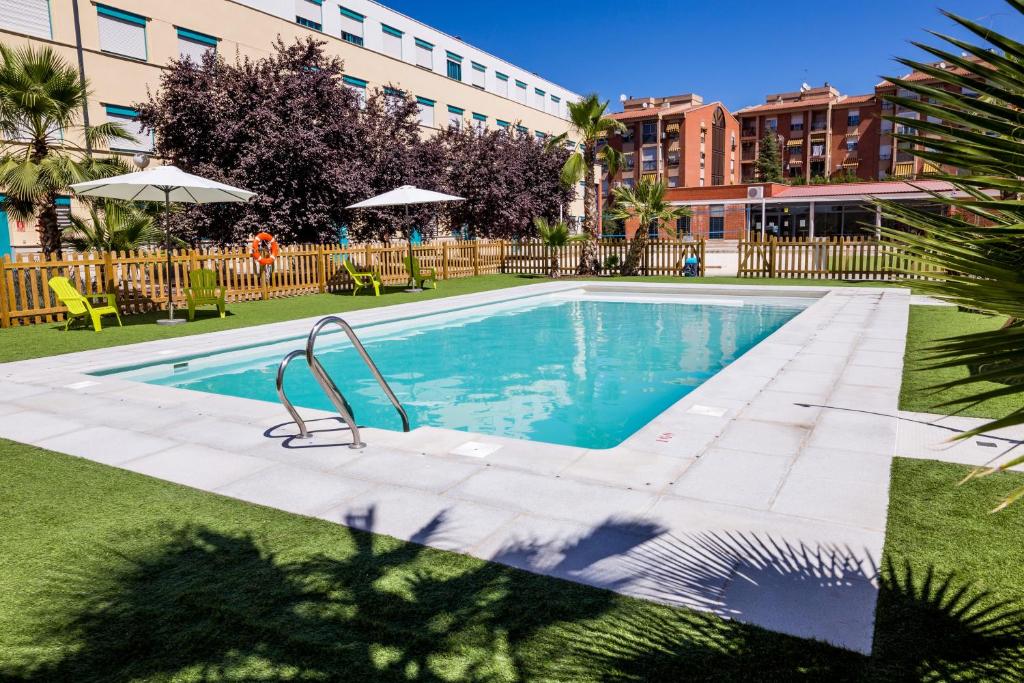 a swimming pool in front of a building at Apartamentos Fernando de los Rios in Granada
