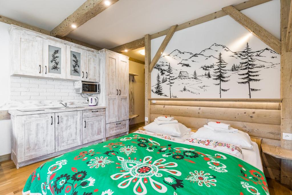 a bedroom with a bed with a green blanket at Willa Vera Zakopane in Zakopane