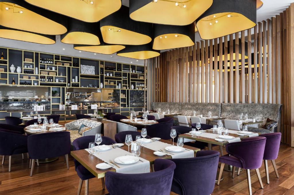 a dining room with tables and purple chairs at Makedonia Palace in Thessaloniki