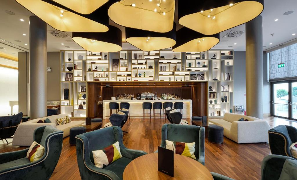 a lobby with tables and chairs and a bar at Makedonia Palace in Thessaloniki