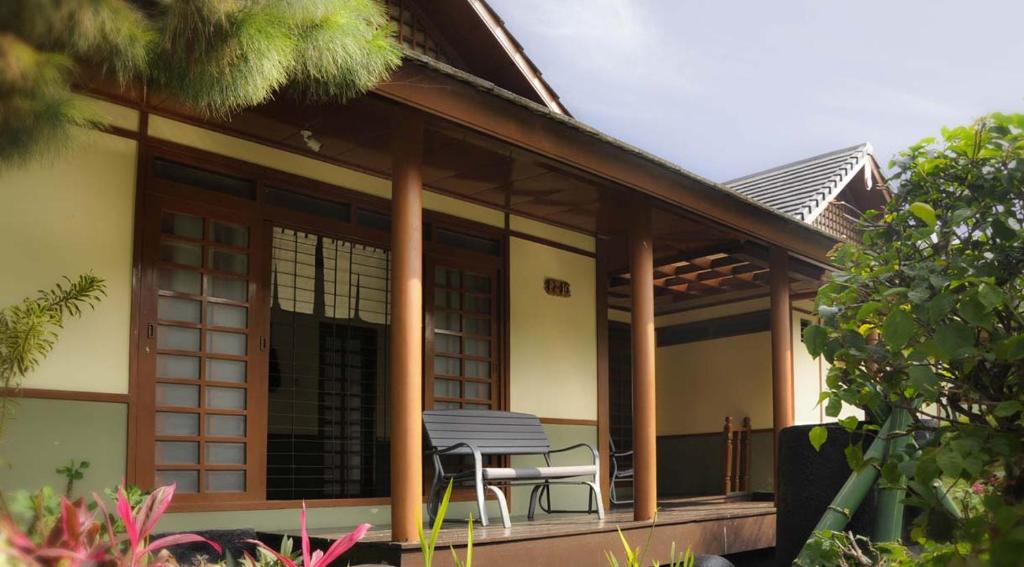 a house with a table and a chair on the porch at Villa Kota Bunga Ade Type Jepang - 0310 in Cikundul