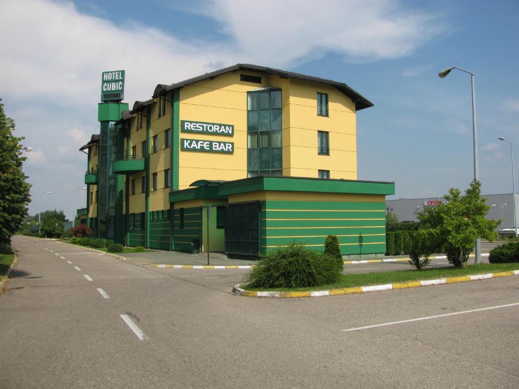 a yellow and green building on the side of a road at Hotel Cubic in Laktaši