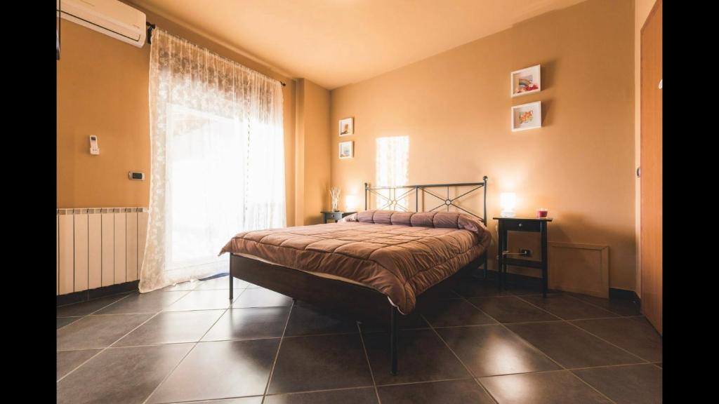 a bedroom with a bed and a large window at B&B Terrazza dell'Etna in Mascalucia