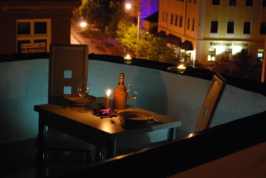 einen Tisch mit einer Flasche Wein und Gläsern auf dem Balkon in der Unterkunft Hostel Foster in Marienbad