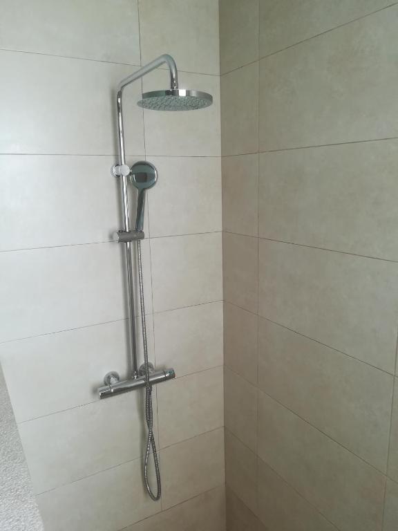 a shower with a shower head in a bathroom at Apartamentos Villa Primera in Cala Figuera