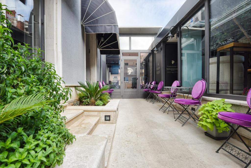 a row of purple chairs and tables on a building at Hotel Galija in Pula