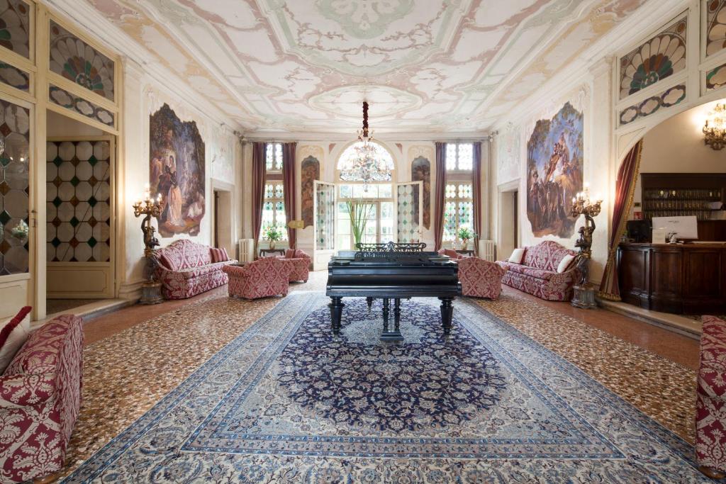 une grande salle avec un piano au milieu dans l'établissement Hotel Villa Condulmer, à Mogliano Veneto