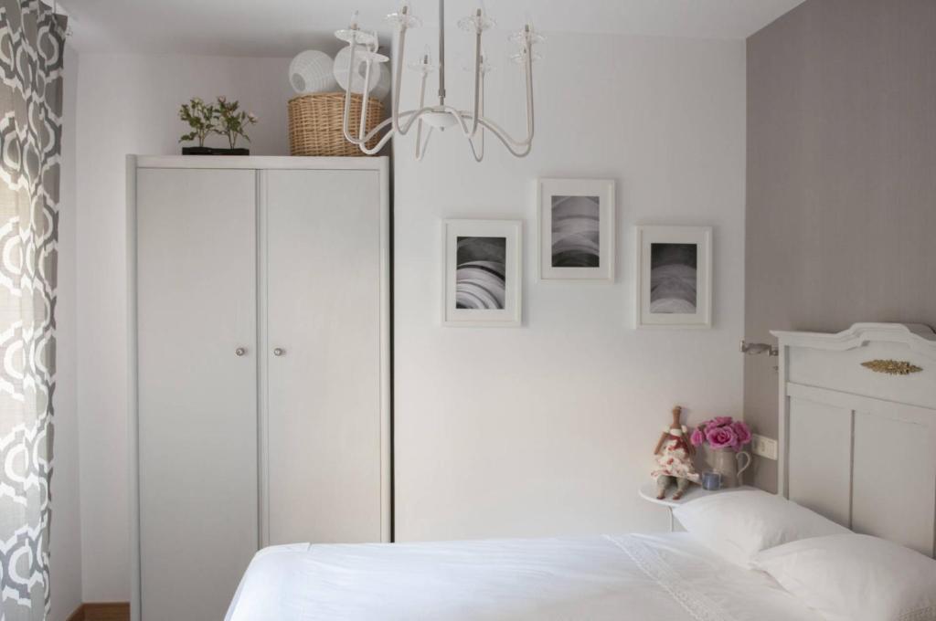 1 dormitorio con armario blanco y cama en El jardí de l'avet, en Lleida