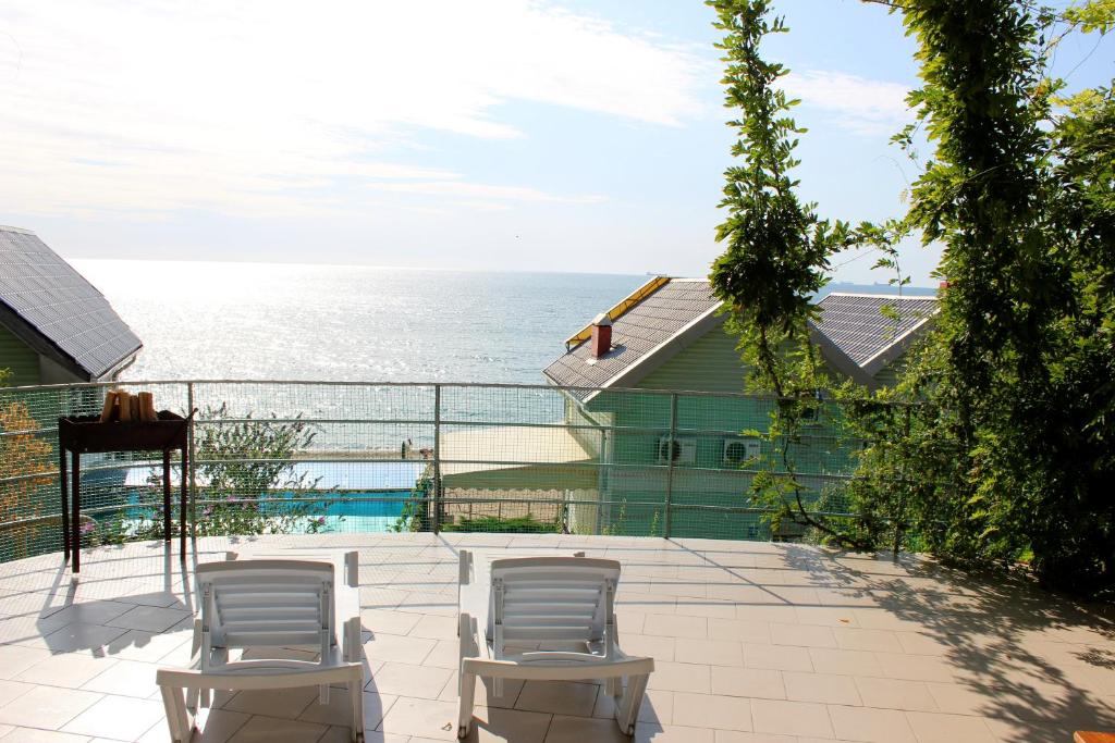 un patio con sillas y vistas al océano en Подвійний котедж з терасою біля моря Совіньон, en Odessa