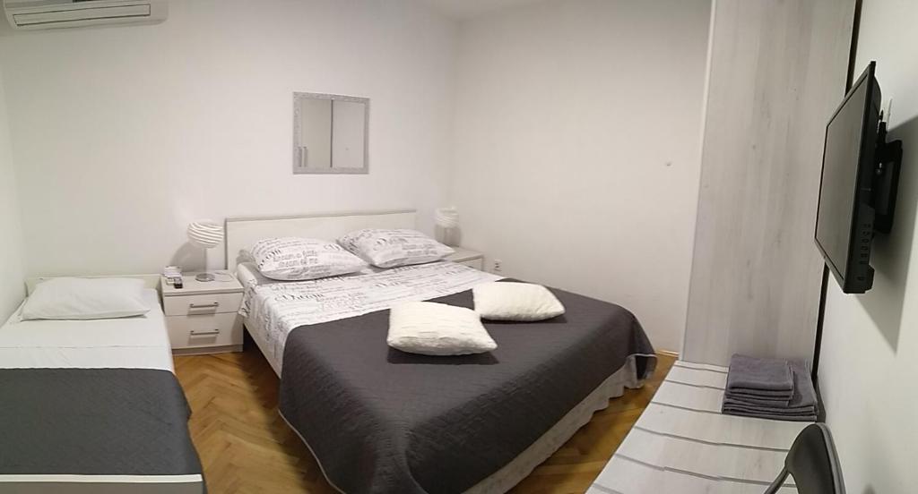 um quarto com 2 camas e uma televisão de ecrã plano em Rooms Ive em Lozovac