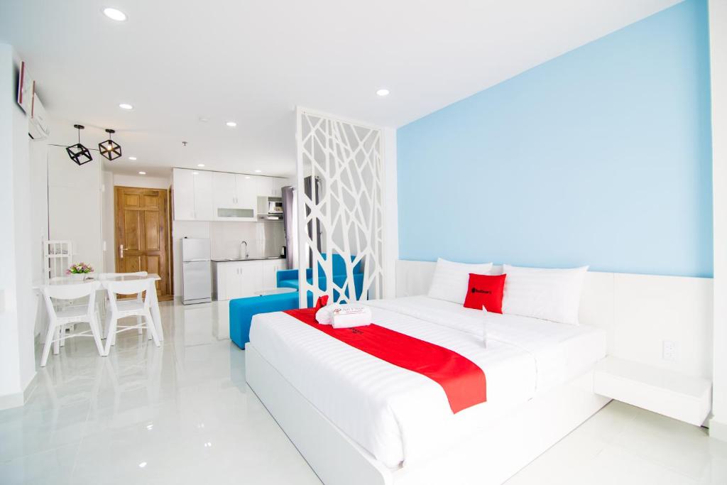 a white room with a white bed and a kitchen at An Phuc House Doan Nhu Hai in Ho Chi Minh City