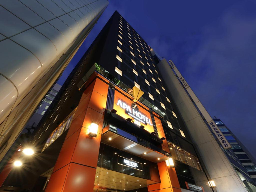 un edificio alto con un cartel delante en APA Hotel Nagoya Sakae Kita en Nagoya