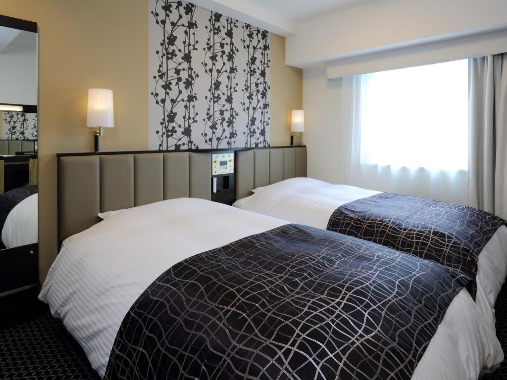 Postel nebo postele na pokoji v ubytování APA Hotel Nagoya Sakae Kita