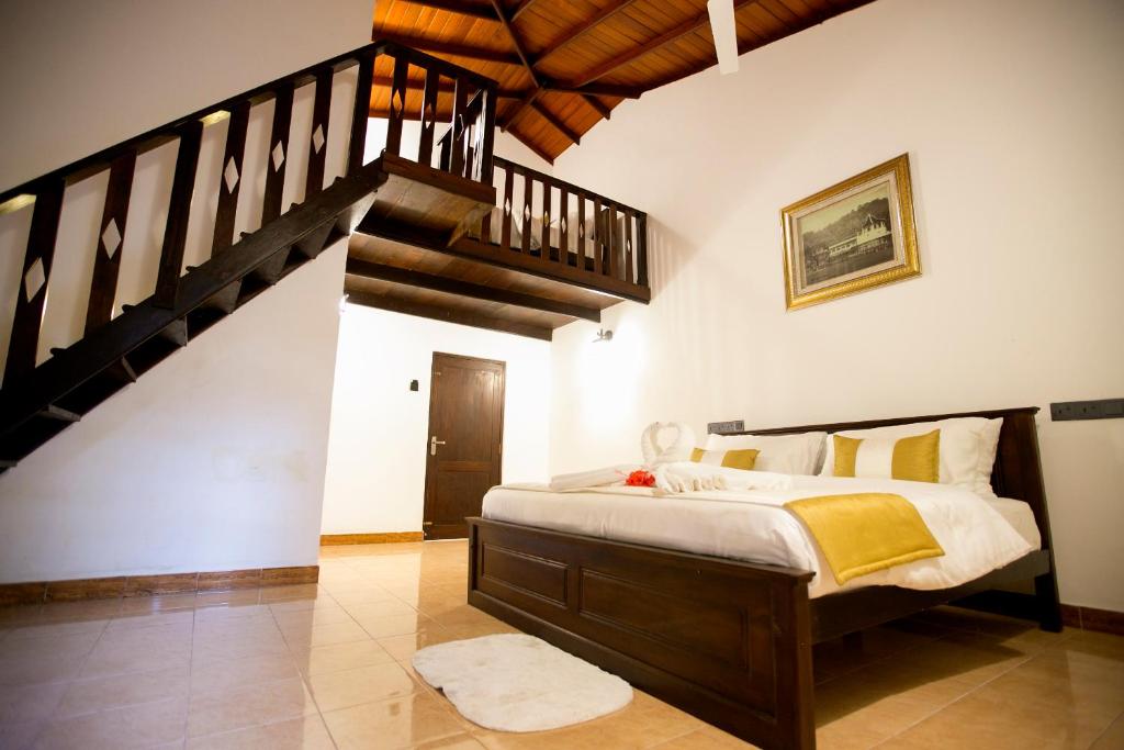 a bedroom with a large bed and a staircase at Grand Casa in Kandy