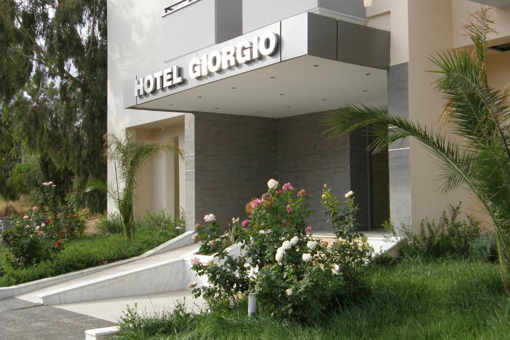un jardín del hotel con flores frente a un edificio en Hotel Giorgio, en Atenas