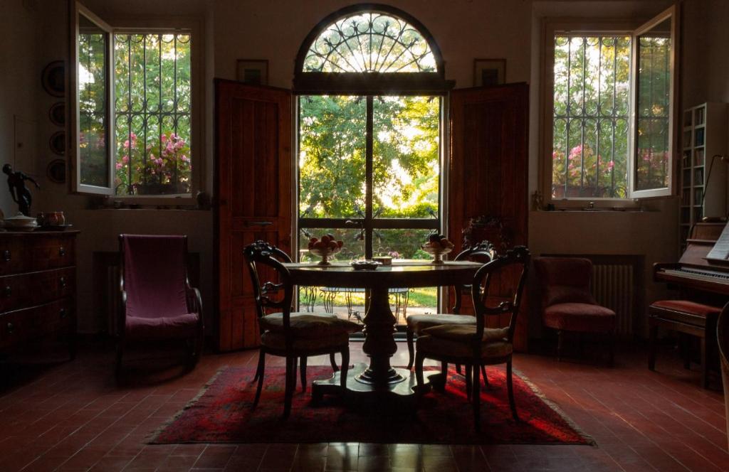 una sala da pranzo con tavolo, sedie e finestre di Cà Morari ad Argenta