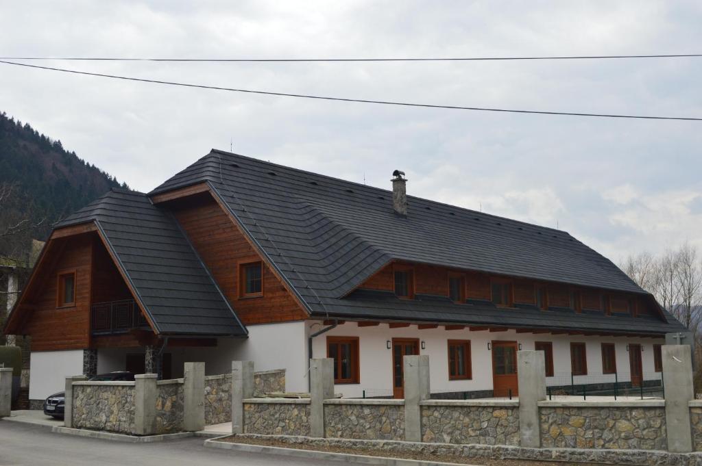ein Holzhaus mit schwarzem Dach in der Unterkunft Penzión Zemanov dvor in Lietavská Svinná