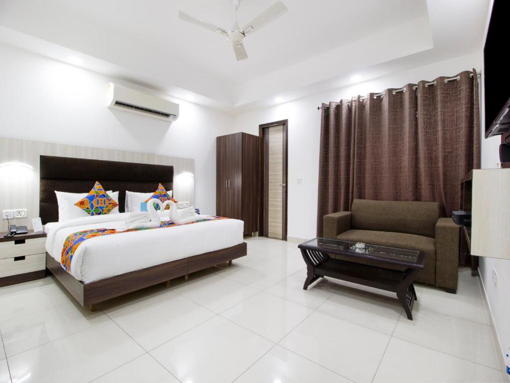 a bedroom with a bed and a couch and a chair at Green Lotus Residency Dwarka in New Delhi