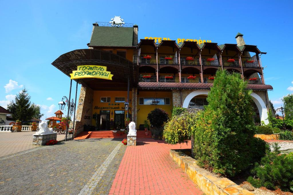 a building with a sign in front of it at Medzhybozhskiy Zamok in Tribukhovtsy