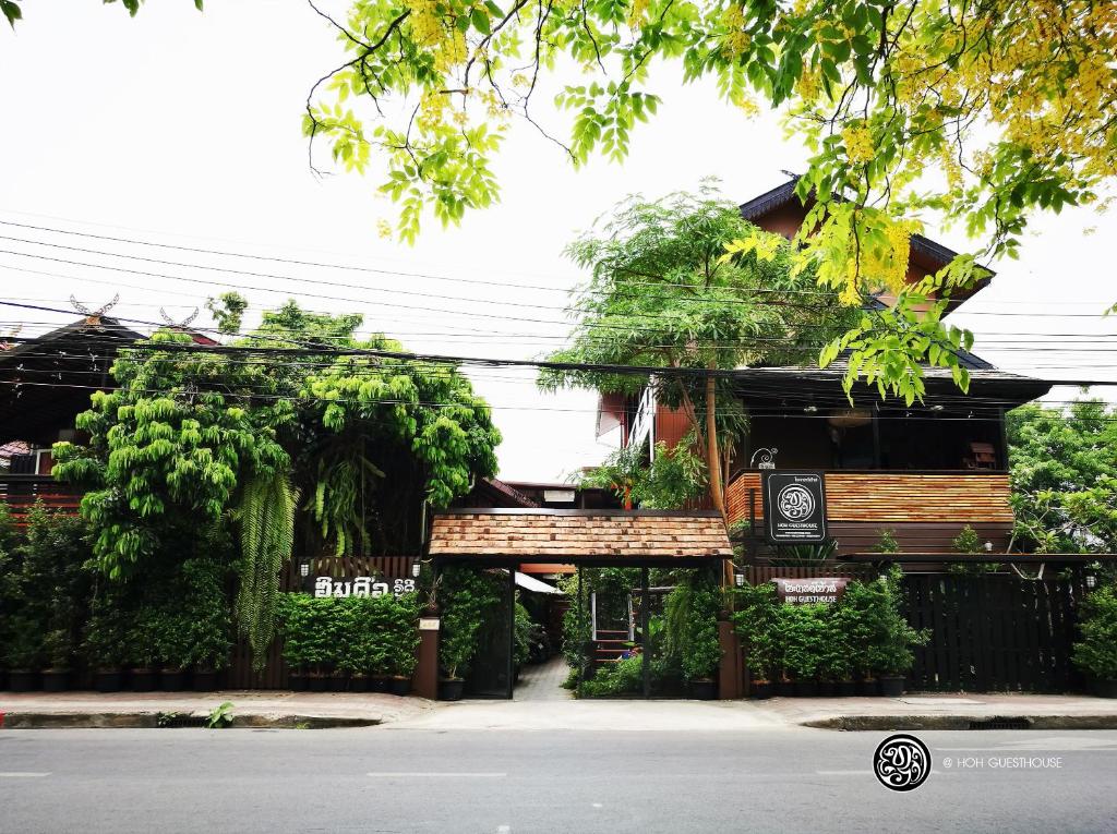 a building with a bench in front of a street at Hoh Guesthouse in Chiang Mai