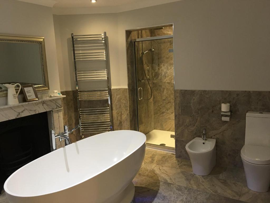 a bathroom with a tub and a shower and a toilet at The Ship Leopard Boutique Hotel - No Children in Portsmouth