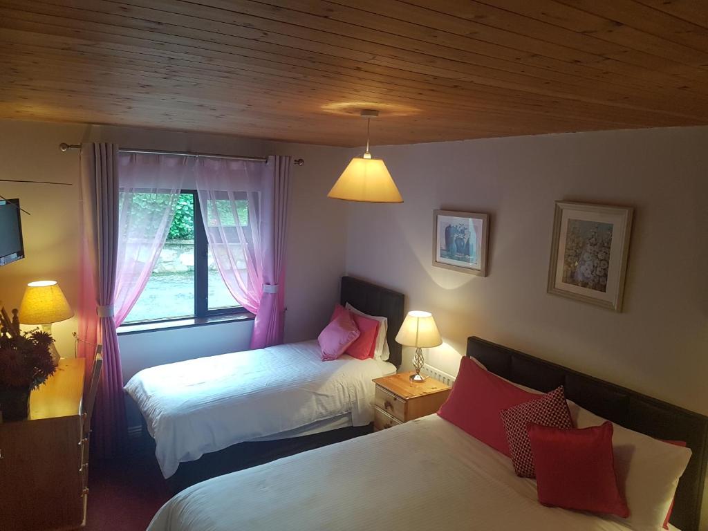 a bedroom with two beds and a window at Ben Breen House B&B in Clifden