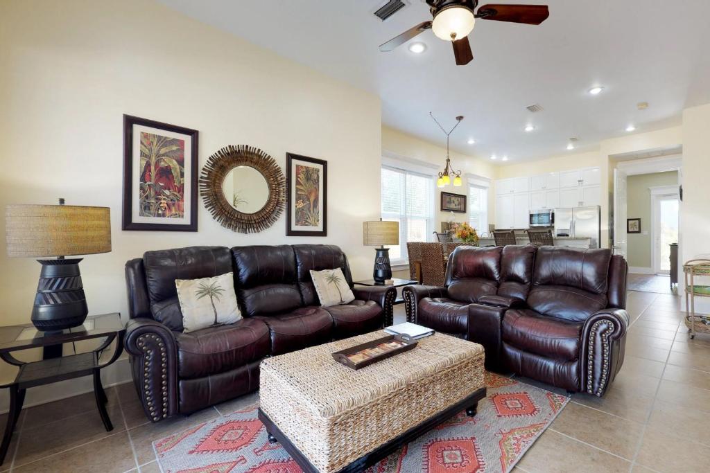 a living room with leather furniture and a ceiling fan at Miramar Beach Villas #110 in Destin