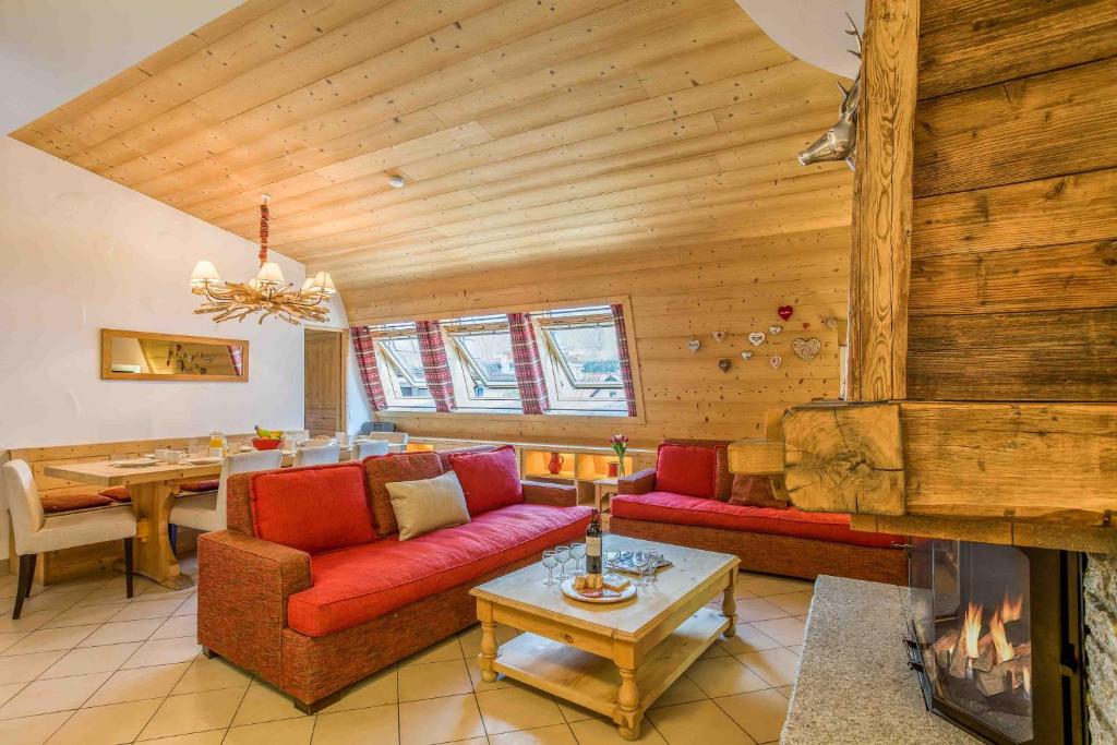 sala de estar con sofá rojo y chimenea en Le Paradis 18 & 18b appts - Chamonix All Year en Chamonix-Mont-Blanc
