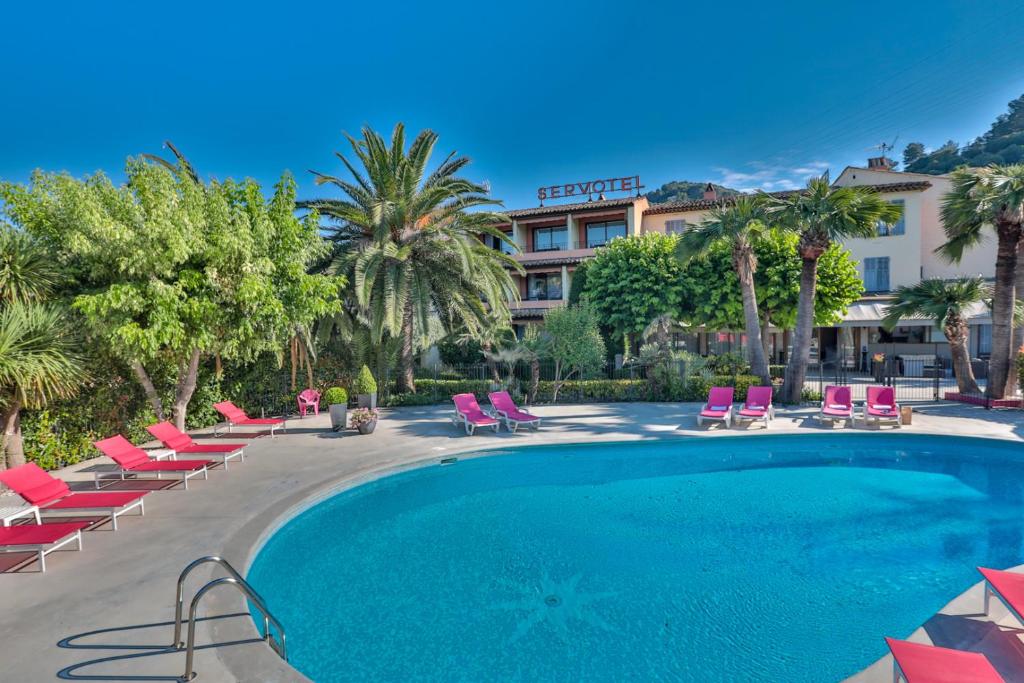 una piscina con tumbonas y un hotel en Servotel Castagniers, en Castagniers