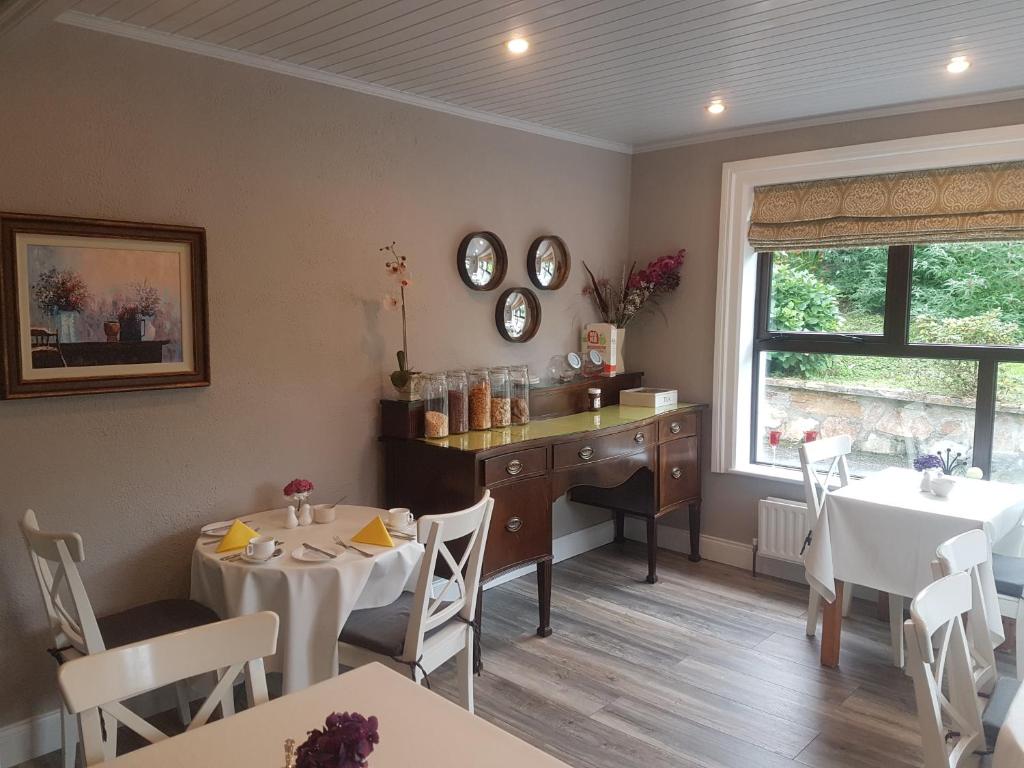 a dining room with tables and a desk and a window at Ben Breen House B&B in Clifden