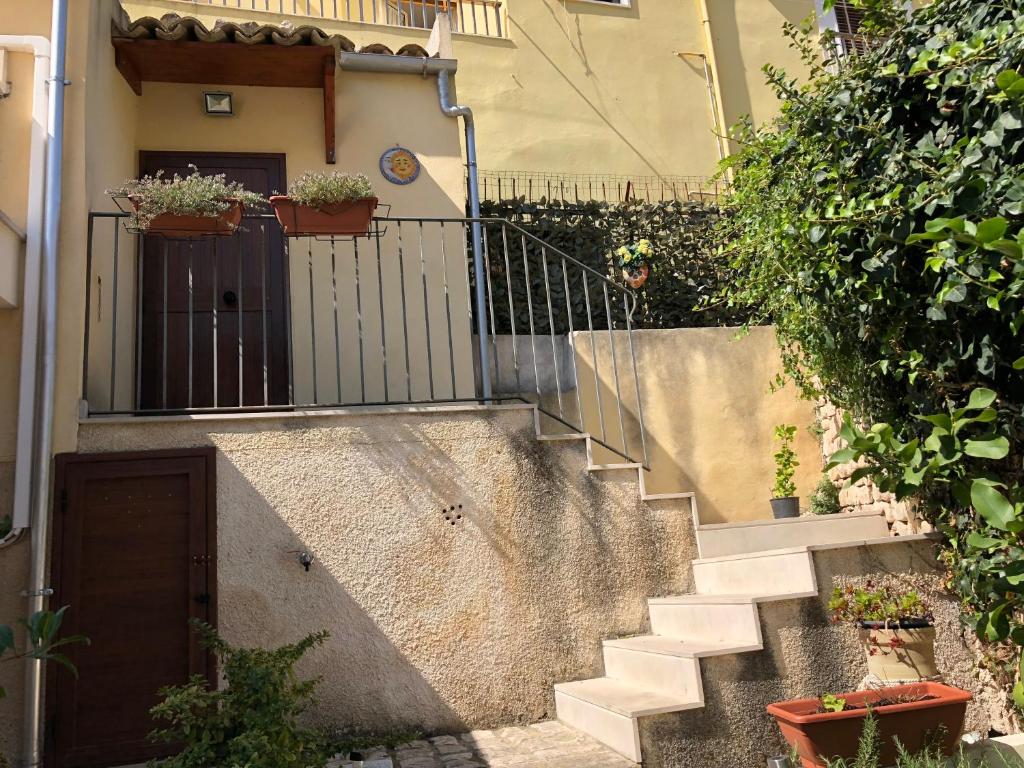a staircase leading up to a house with potted plants at SoleLuna House in Modica