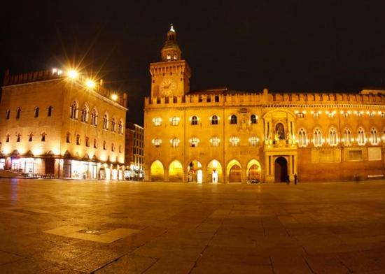 un grand bâtiment avec une tour d'horloge la nuit dans l'établissement Affittacamere Polese, à Bologne