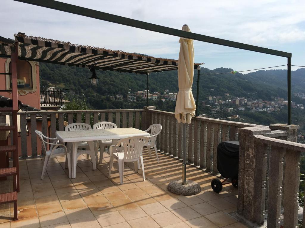 a patio with a table and chairs and an umbrella at La Casa di Zoe in Uscio