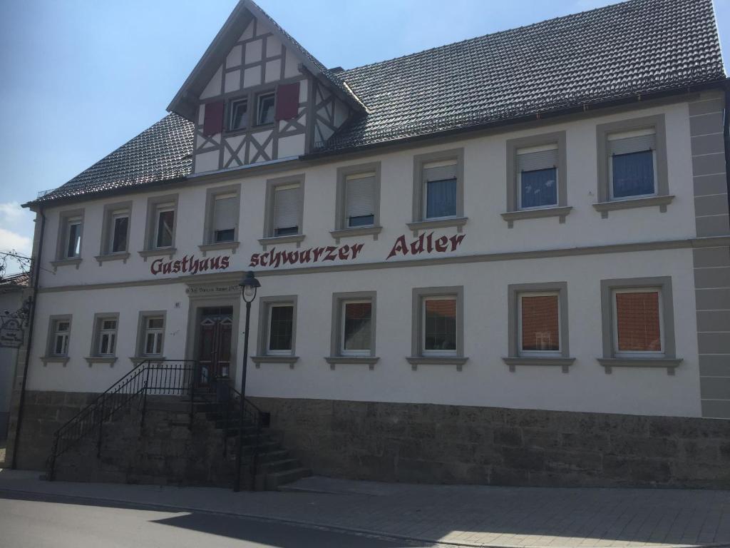 ein weißes Gebäude mit einem Schild, das eine Gastronomieanalyse liest in der Unterkunft Landgasthof Zum Schwarzen Adler in Markt Nordheim