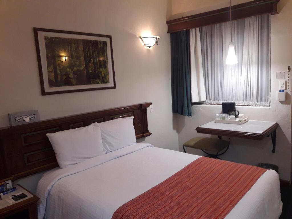 Postel nebo postele na pokoji v ubytování Hotel Alameda Centro Historico