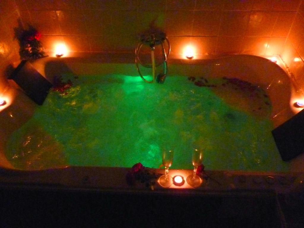a bath tub filled with green water with candles in it at Casa rural el turmell in Xert
