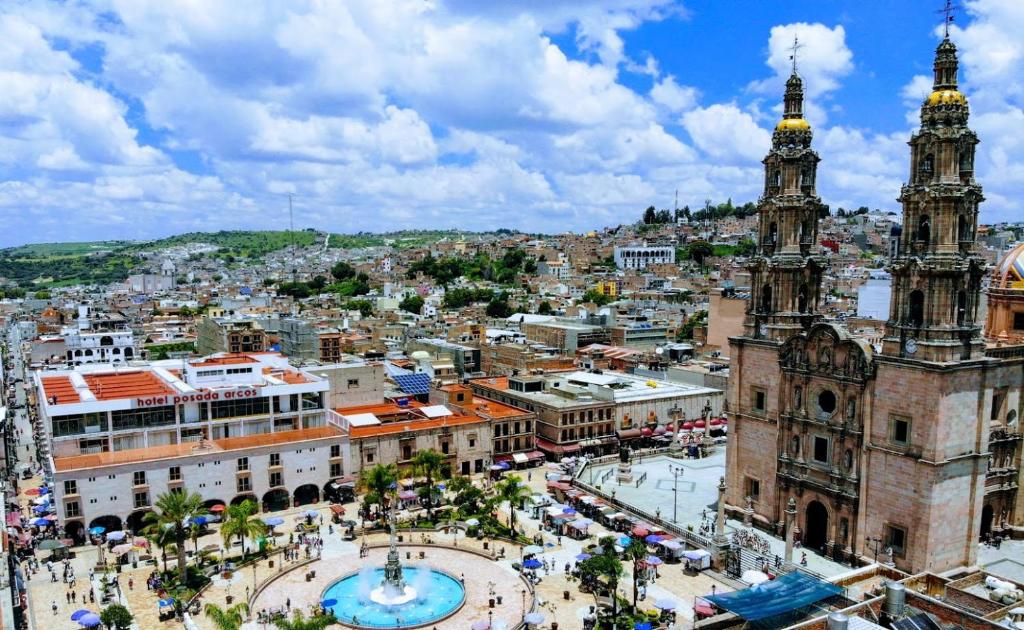 een luchtzicht op een stad met een klokkentoren bij Hotel Posada Arcos in San Juan de los Lagos