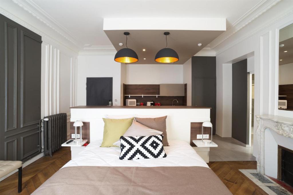 a bedroom with a large bed with two pillows at Les cles du 27 Paris in Paris