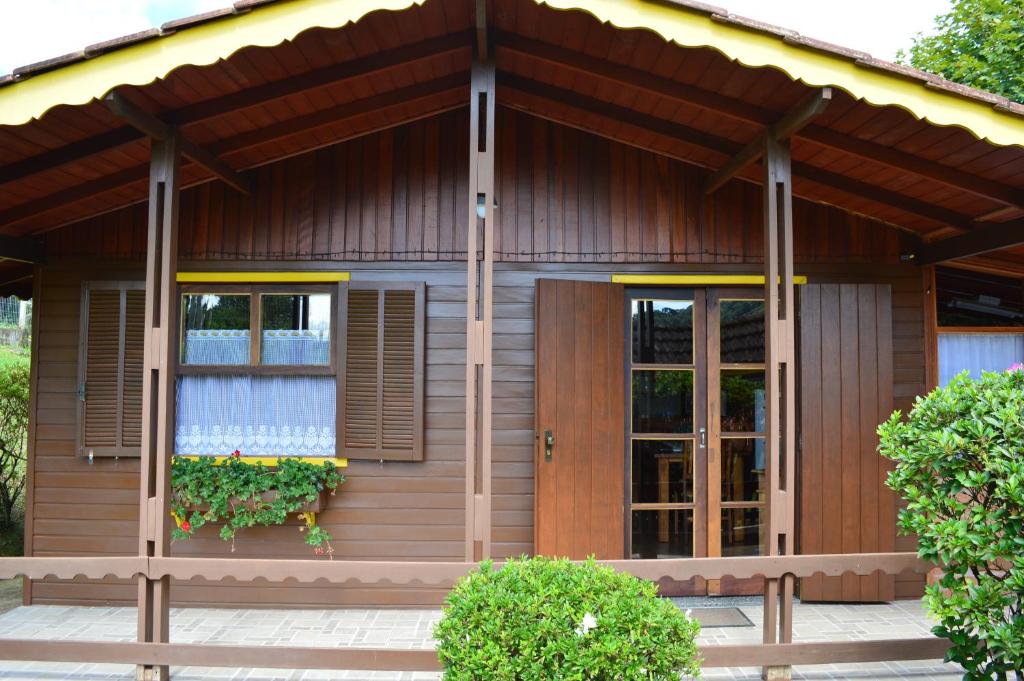 Casa de madera pequeña con puerta grande y ventanas en Meu Cantinho, en Monte Verde