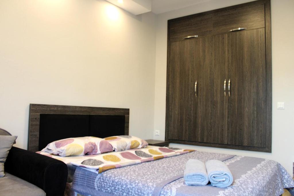 a bedroom with a bed with a cabinet and two slippers at Guest House on Meskheti in Borjomi