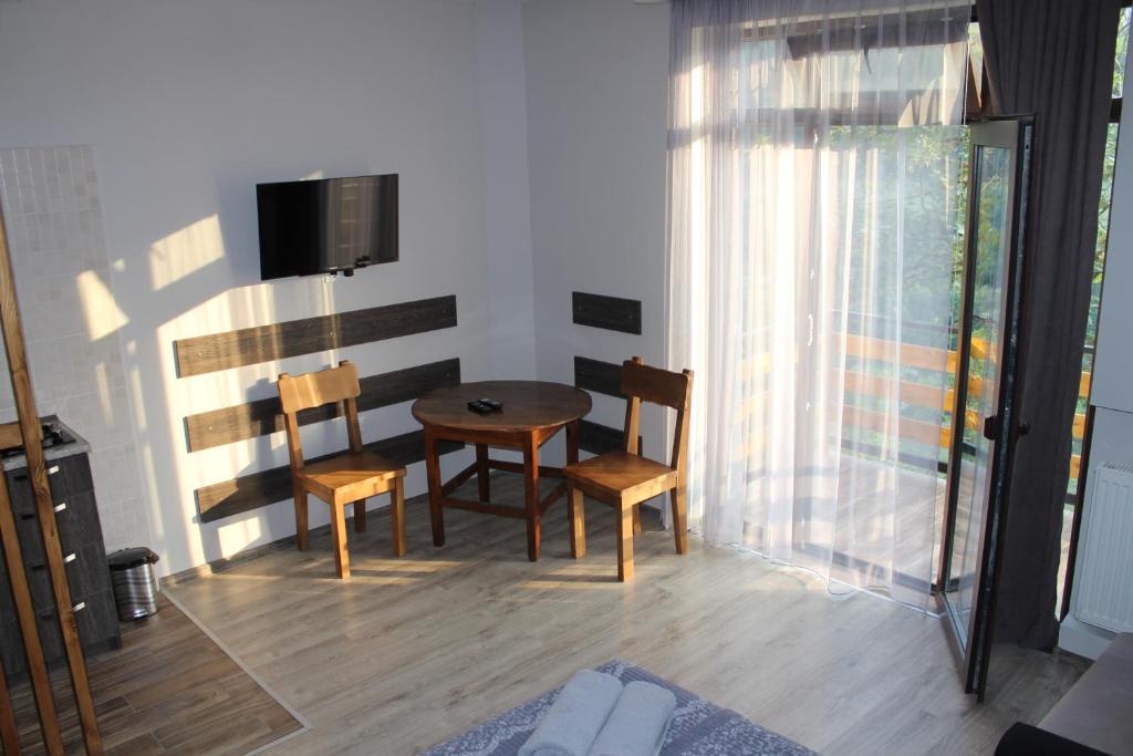 a room with a table and chairs and a television at Guest House on Meskheti in Borjomi