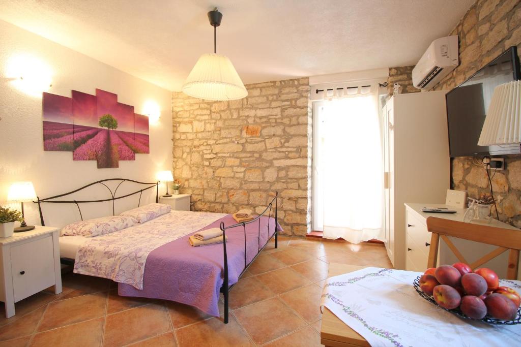 a bedroom with a bed and a stone wall at Studio Driovier 11 in Rovinj