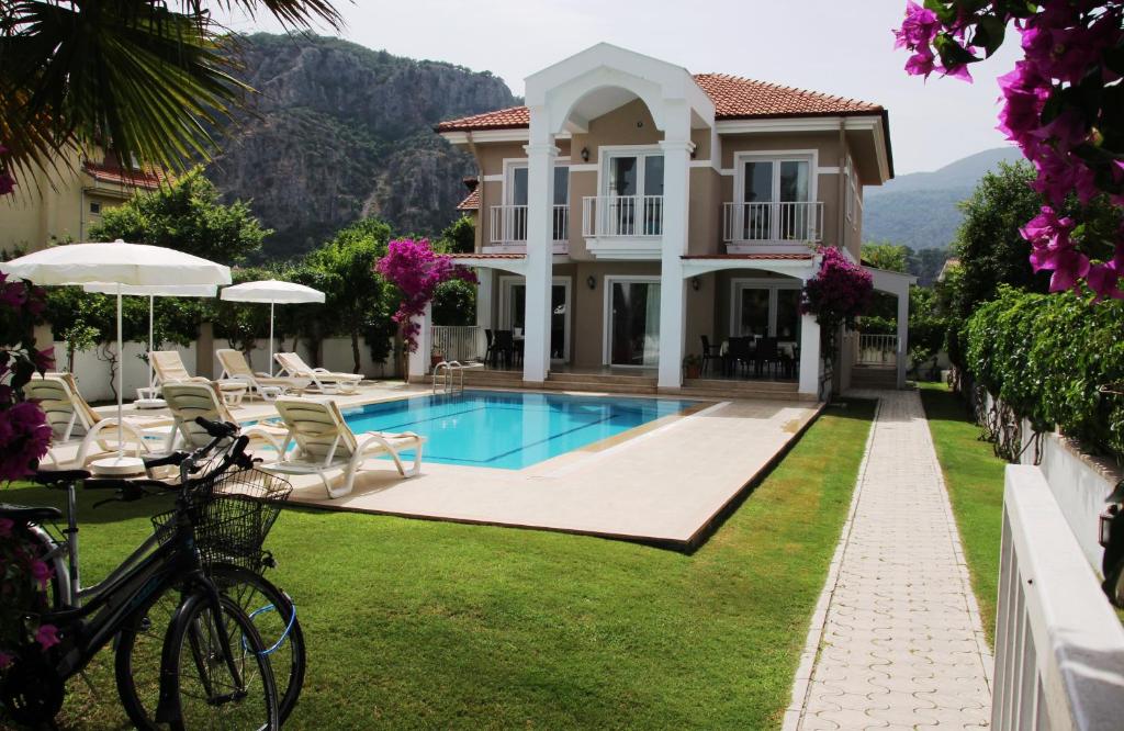 uma villa com uma piscina e uma casa em Dalyan Villa Amazon em Dalyan