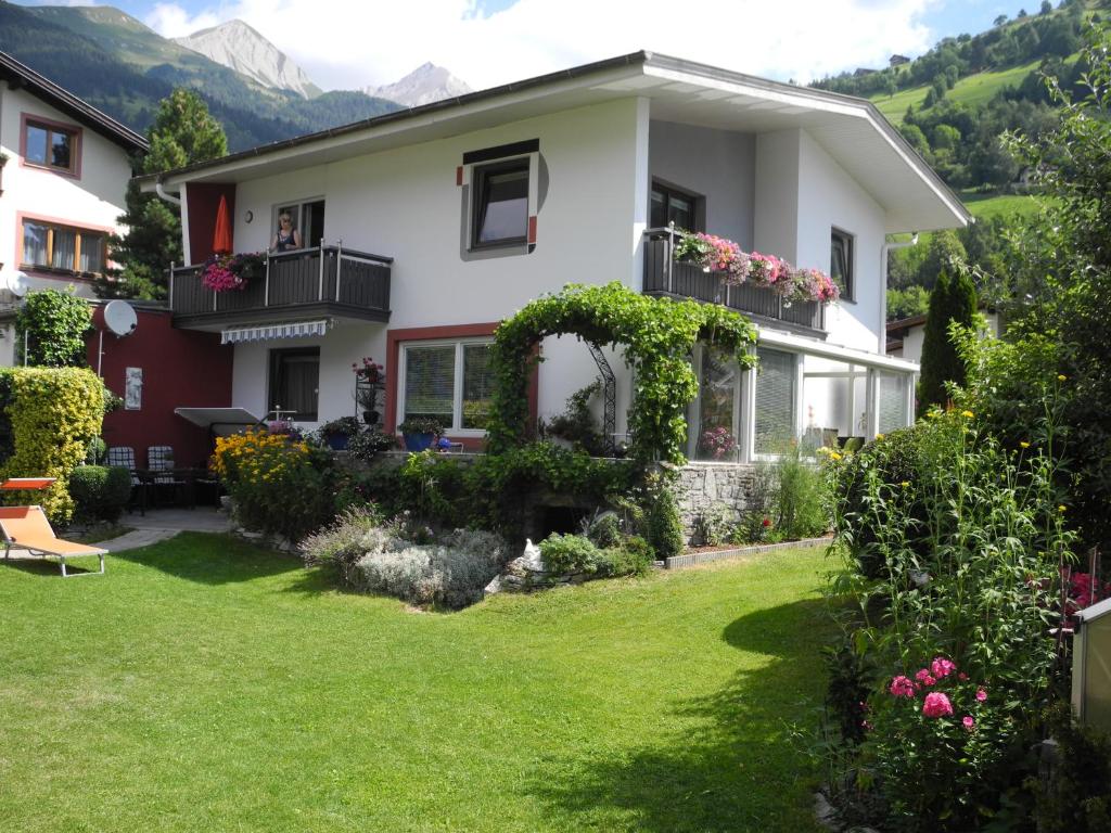 ein Haus mit einem Garten mit grünem Gras und Blumen in der Unterkunft Haus Herzog in Matrei in Osttirol